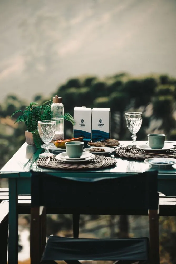 Mesa posta ao ar livre com produtos da Ocean Drop ao centro, mostrando como os suplementos podem fazer parte da rotina diária.