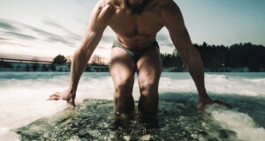 Homem entrando em banheira de gelo, ilustrando quanto tempo ficar na banheira de gelo para recuperação física
