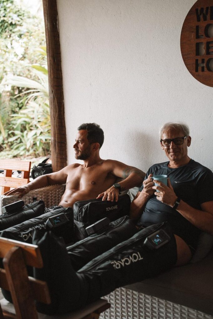 Pessoas utilizando bota de compressão da Tovcare como estratégia de massagem para acelerar a recuperação muscular após treinos intensos.