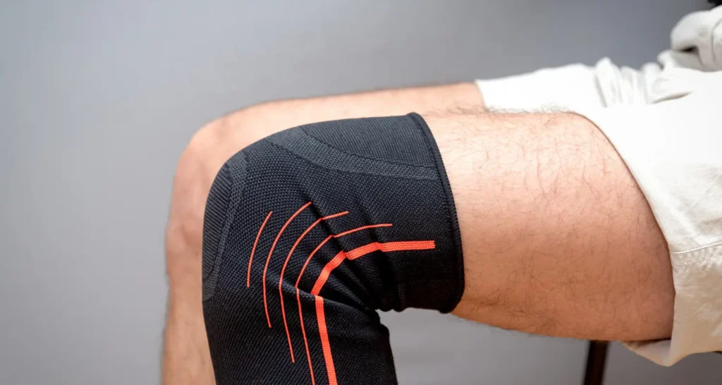 Pessoa usando joelheira, ilustrando suporte específico para o joelho em comparação com outros tipos de acessórios de estabilização.