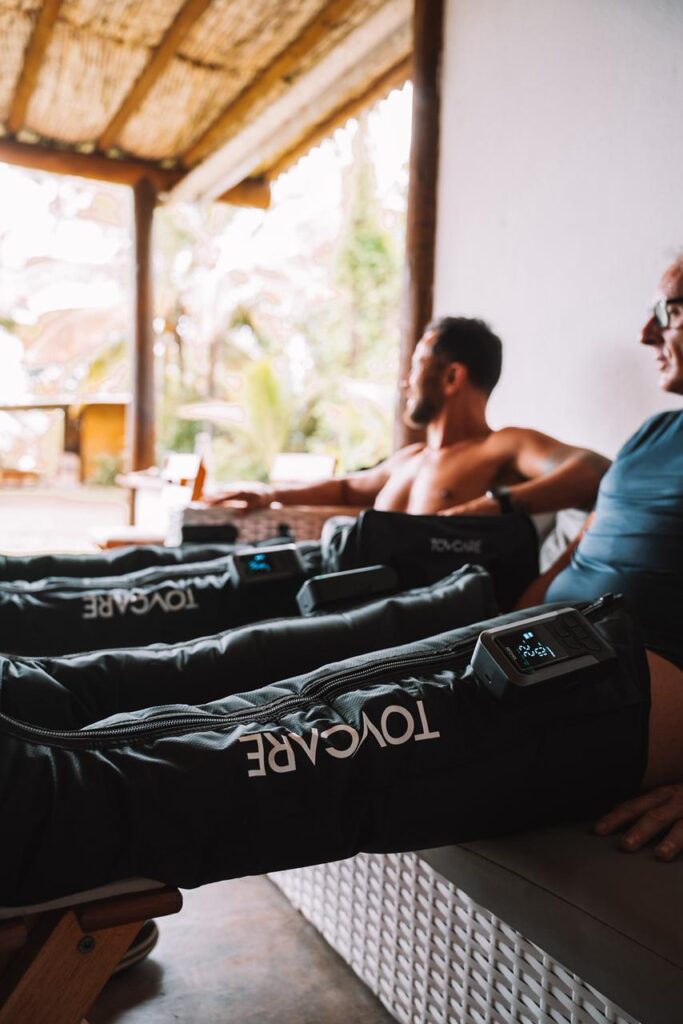 Equipamentos de recuperação da Tovcare sendo usados após o treino para aliviar fadiga muscular e melhorar o conforto das pernas durante o descanso.