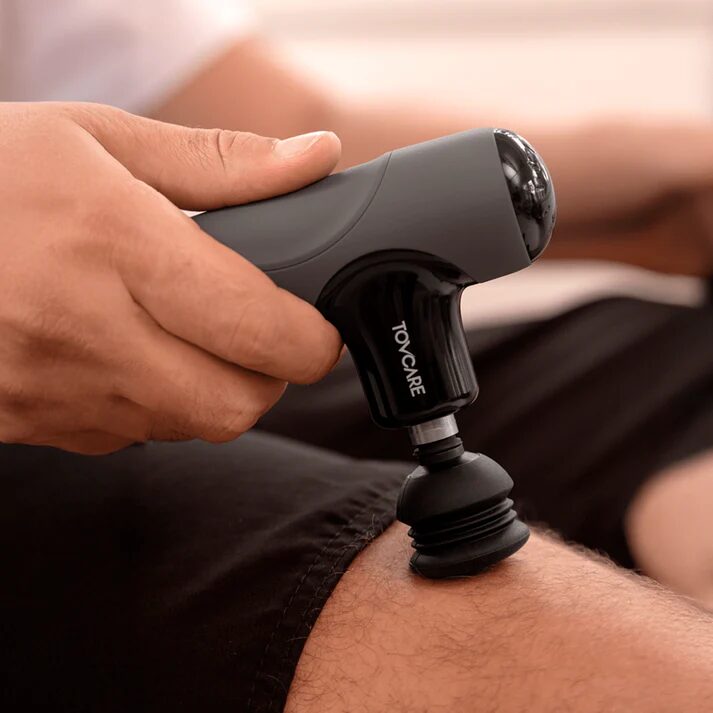 Ferramenta de liberação muscular da Tovcare sendo aplicada na coxa para aliviar tensão e auxiliar na recuperação após o treino.